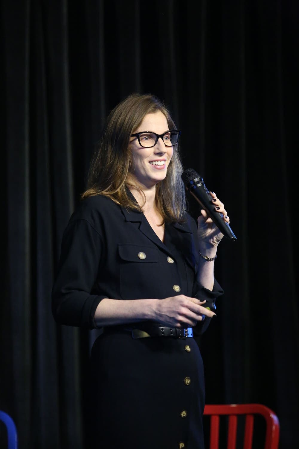Michal Levi Arbel speaking on stage with a microphone